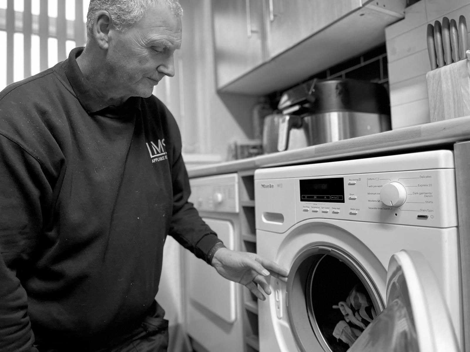 LMS Appliance Repairs technician inspecting a Miele washing machine in Bristol